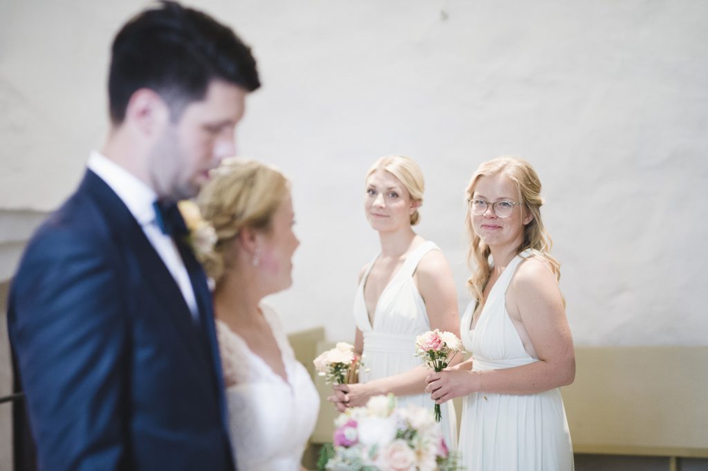 Bruden tittar på tärnorna under vigsel i Veckholms kyrka