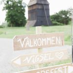 Välkommenskylt framför klocktorn vid Veckholms kyrka