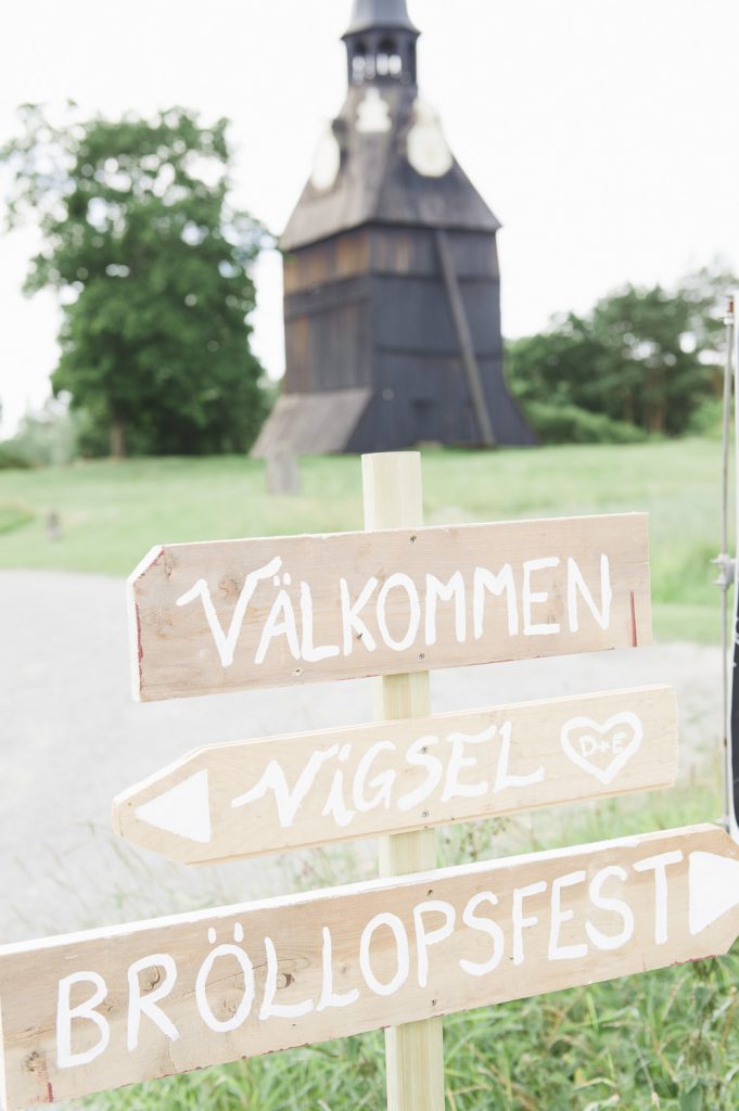 Välkommenskylt framför klocktorn vid Veckholms kyrka